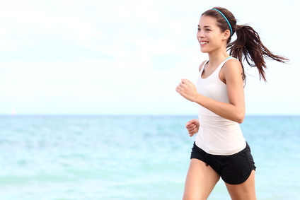 Frau joggt am Meer und ist glücklich Sport 